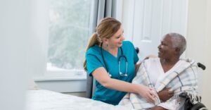 A female nurse assisting an elderly woman.